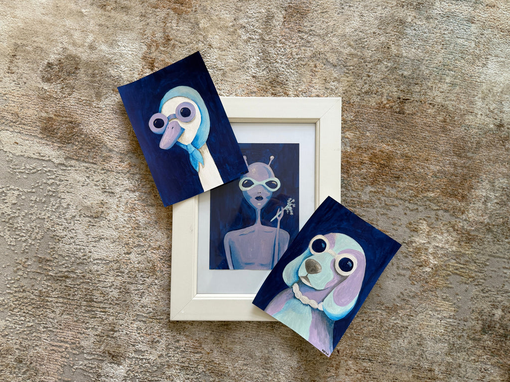 Set of three small artworks on a textured surface
