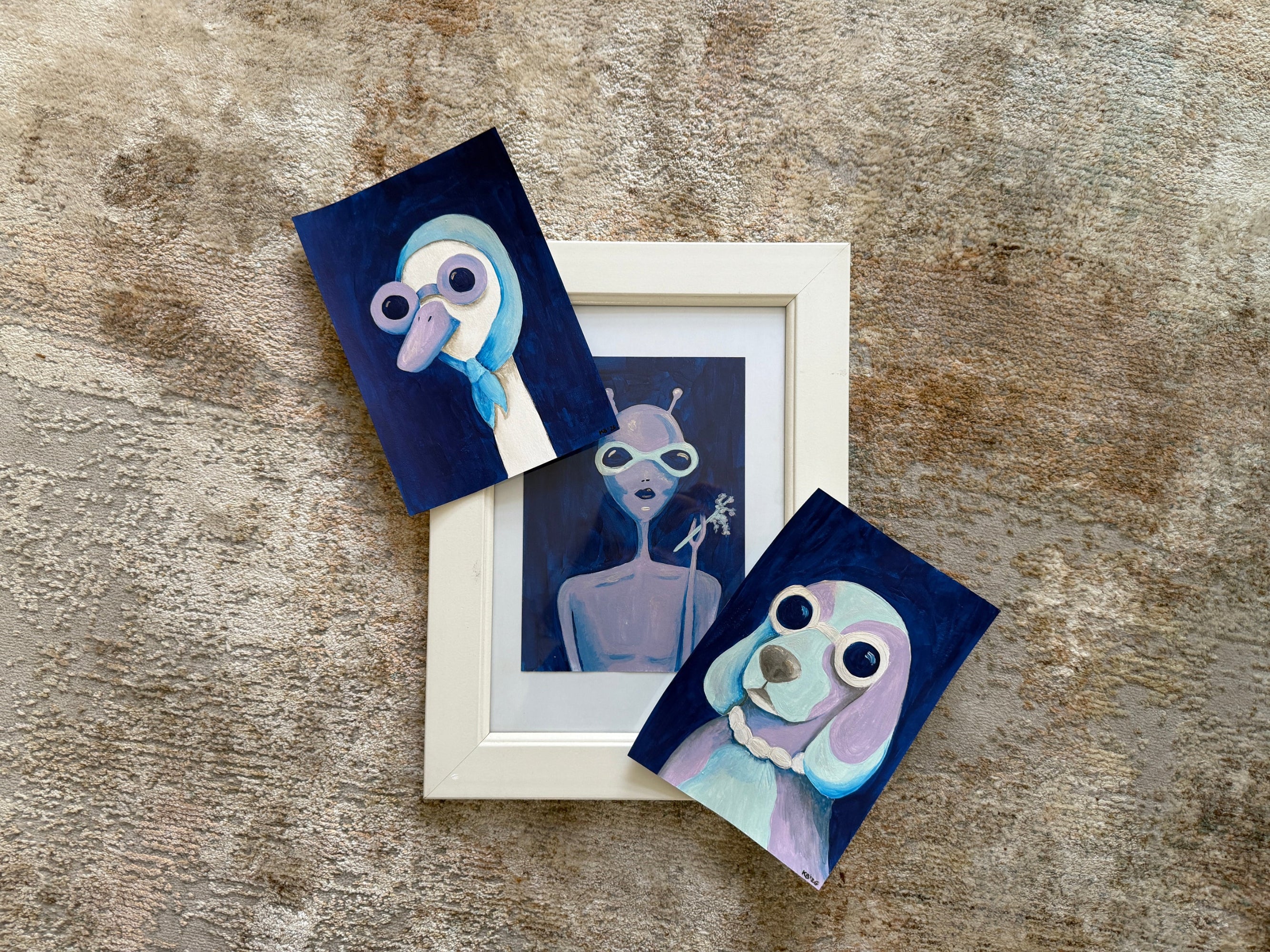 Set of three small artworks on a textured surface