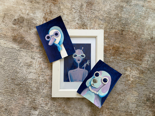Set of three small artworks on a textured surface