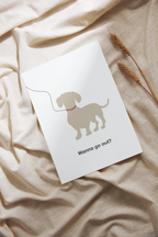 White card with a dog illustration and text 'Wanna go out?' on a beige fabric background